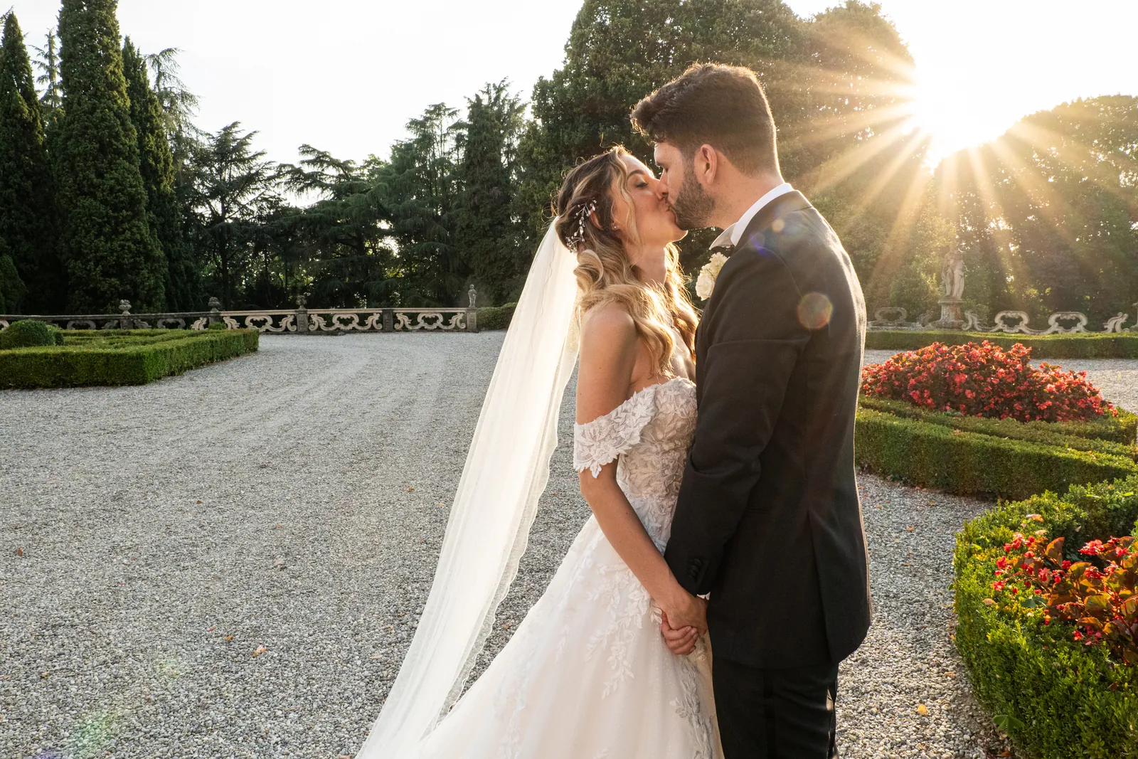 Gli sposi si baciano controluce nel giardino all'italiana di Villa Subaglio