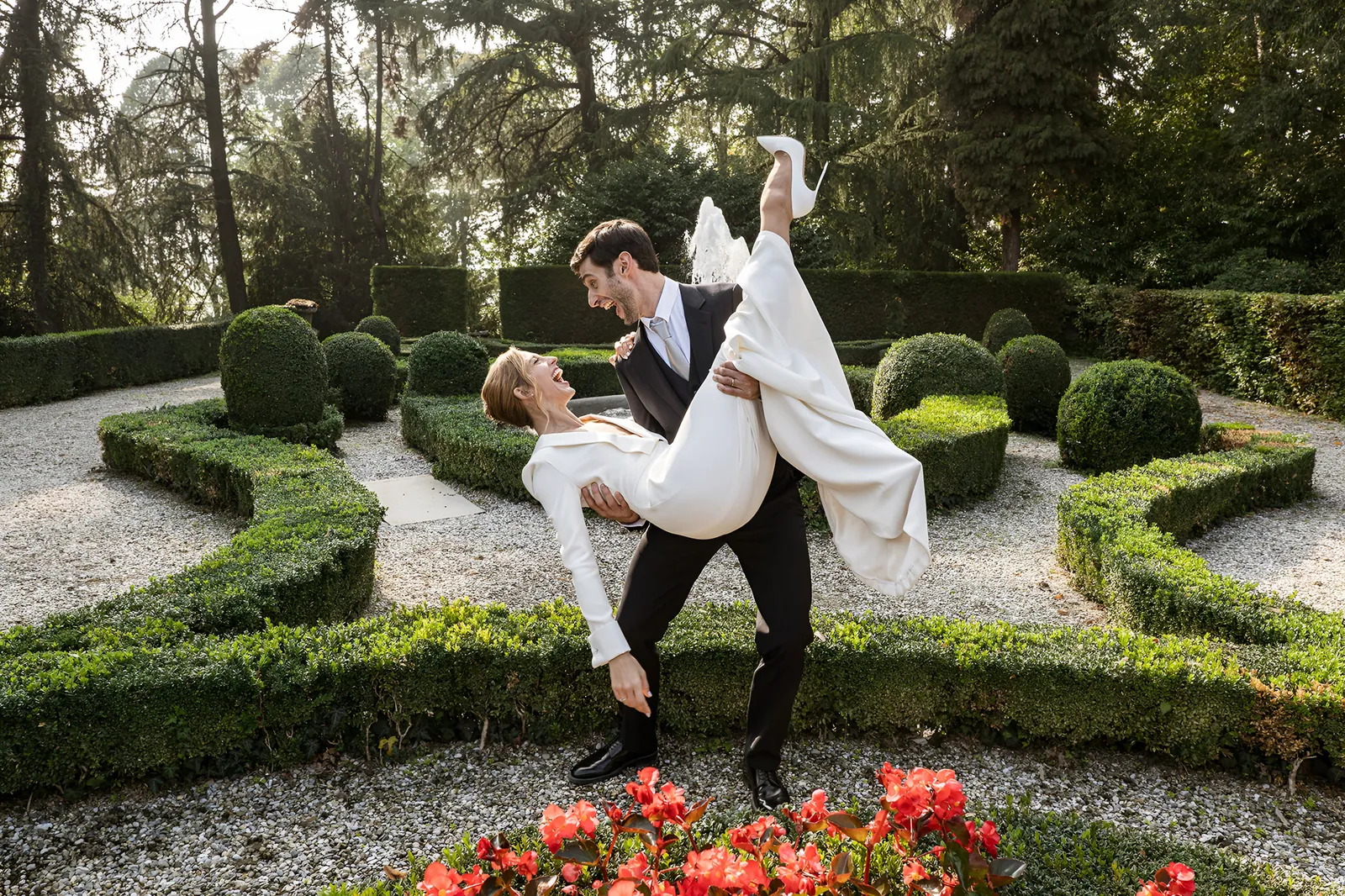 Lo sposo solleva la sposa in un passo di danza nel giardino